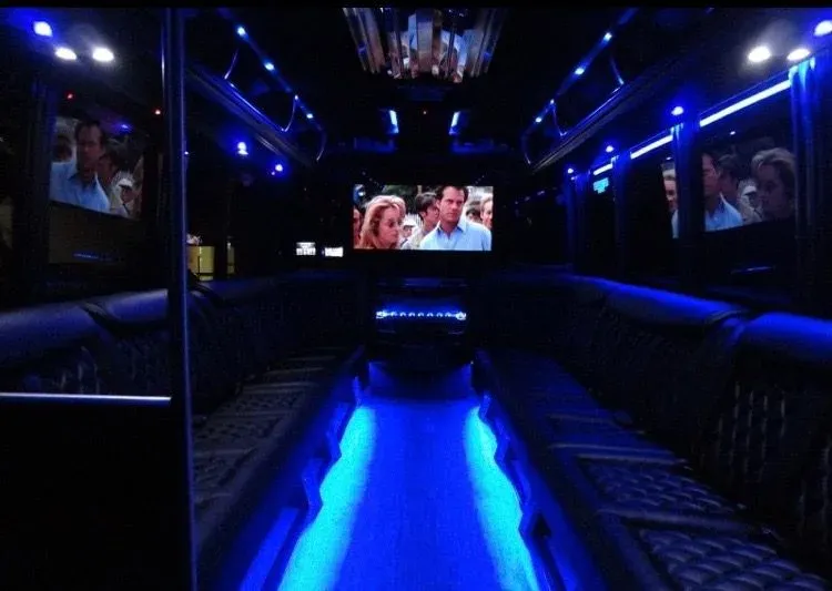 Luxurious interior of a Miami Limo Car party bus featuring blue lighting and comfortable seating.